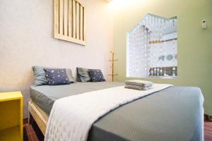 a bedroom with a bed with blue sheets and a window at Citra Condong Catur in Seturan