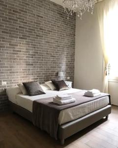 a bedroom with a large bed against a brick wall at Maglo Centro in Bologna +10 photos