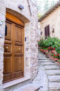 a wooden door in a stone building with plants at Charme in Spello in Spello