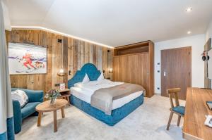 a hotel room with a bed and a couch at Superior Hotel Edelweiss in Obertauern