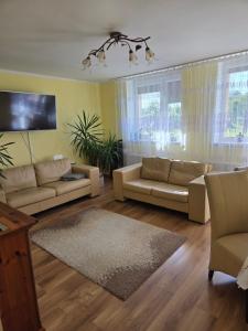 a living room with couches and a flat screen tv at Apartament blisko Świeradowa in Mirsk