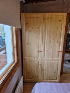a wooden cabinet in a bedroom next to a window at Rantamökki 28 in Syöte