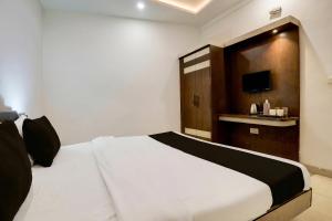 a bedroom with a white bed and a tv at Hotel O Taj Nagri Near Taj Mahal East Gate Formerly Riviera in Agra