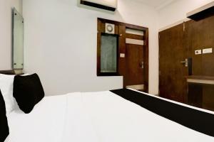 a bedroom with a white bed and a bathroom at Hotel O Taj Nagri Near Taj Mahal East Gate Formerly Riviera in Agra +70 photos