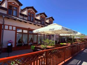 a restaurant with tables and umbrellas in front of a building at Hotel Neo Międzyrzecz in Międzyrzecz