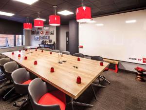 a conference room with a large wooden table and chairs at ibis Birmingham Centre New Street Station Hotel in Birmingham