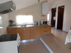a kitchen with a sink and a microwave at Casa do Fundo do Povo - Serra da Estrela in Cortes do Meio