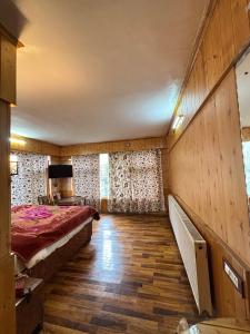 a room with a bed and a tv in it at Hotel king palace in Pahalgām