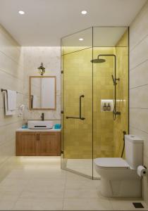 a bathroom with a shower and a toilet and a sink at Noska Hotel Sunset Town Sea View & Fireworks in Phú Quốc +45 photos
