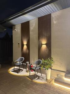 two chairs and a table on a patio at night at Sherpa space in Almaty