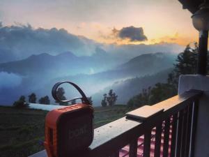 a suitcase sitting on a balcony with a view of mountains at Hotel Skyline in Kanatal