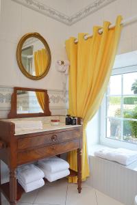 a bathroom with a vanity and a mirror and a window at Hostellerie de la Motte jean in Saint-Coulomb