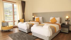 a hotel room with two beds and a balcony at Golden Paddyfield in Paro