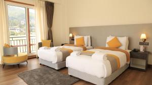 a hotel room with two beds and a balcony at Golden Paddyfield in Paro