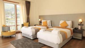 a hotel room with two beds and a balcony at Golden Paddyfield in Paro