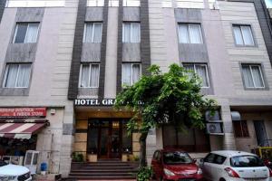 a hotel building with cars parked in front of it at Hotel Grand In Near 2 Min From Vaishali Metro Station in Ghaziabad