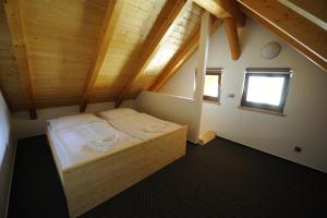 1 dormitorio con 1 cama en una habitación con techos de madera en BalonCentrum Břestek, en Břestek