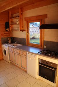 uma cozinha com um fogão e um lavatório em chalets de combebelle em Saint-Léger-les-Mélèzes