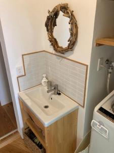 a bathroom with a sink and a mirror on the wall at 丘の上の小さなスローリゾート フェニックスの宿 in Miyazaki +41 photos