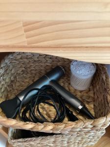 a basket with a hair dryer and a cord at 丘の上の小さなスローリゾート フェニックスの宿 in Miyazaki