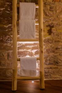 a towel rack with towels on it in front of a stone wall at Charme in Spello in Spello +41 photos