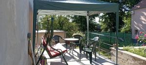 a patio with a table and chairs under a canopy at Pihenőház in Pécs