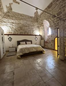 a bedroom with a bed and a brick wall at Apulia Luxury House in Toritto
