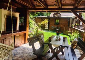 a patio with a table and chairs on a porch at Sovia Wellness Chata, Sauna & Jacuzzi, Slovenský raj in Smižany