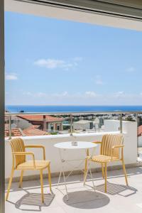 a patio with two chairs and a table on a balcony at Old Town 63 Luxury Residence in Paphos