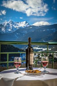 una bottiglia di vino seduta su un tavolo con due bicchieri di To Kallion a Klávsion
