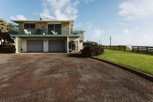 a house with a large driveway in front of it at ABC on Wanaka Bay - beachfront home w. ocean views in New Plymouth