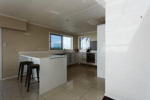 a kitchen with white cabinets and a counter top at ABC on Wanaka Bay - beachfront home w. ocean views in New Plymouth