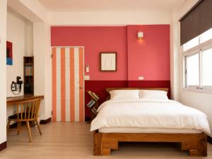 a bedroom with a large bed and a red wall at 大樹林 Mori Mori 包棟民宿 寵物友善 附車位 in Tainan