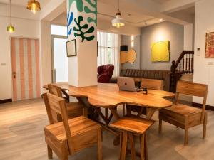 a dining room with a table and chairs with a laptop at 大樹林 Mori Mori 包棟民宿 寵物友善 附車位 in Tainan