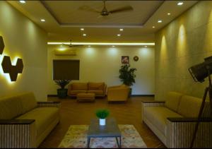 a living room with two couches and a tv at Mannath Lake House in Murinjupuzha +12 photos