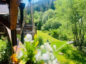 a view of a garden from the porch of a house at Sovia Wellness Chata, Sauna & Jacuzzi, Slovenský raj in Smižany