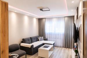 a living room with a couch and a tv at Apartman Harmony in Prijedor