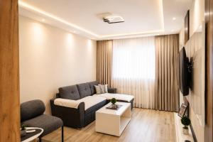 a living room with a couch and a tv at Apartman Harmony in Prijedor +2 photos