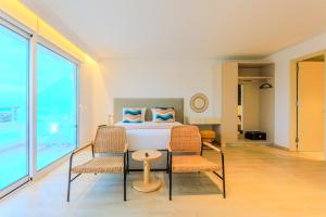 a bedroom with a bed and two chairs at Old Town 63 Luxury Residence in Paphos