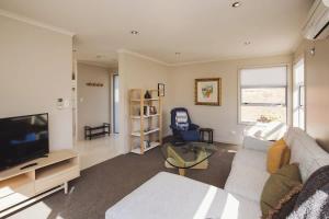 a living room with a couch and a tv at Sail-Shaped Townhouse in New Plymouth in New Plymouth