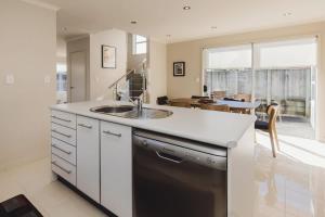 a kitchen with a sink and a dishwasher at Sail-Shaped Townhouse in New Plymouth in New Plymouth