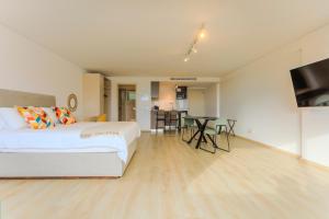 a bedroom with a white bed and a dining room at Old Town 63 in Paphos