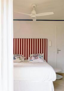 a bed with a red and white striped headboard at Exceptional Apartment In Cannes' Countryside in Spéracèdes