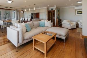 a living room with a white couch and a table at Clifftops - oceanfront retreat in Oakura Beach in Oakura +60 photos