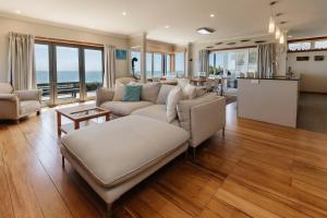 a living room with a couch and a table at Clifftops - oceanfront retreat in Oakura Beach in Oakura