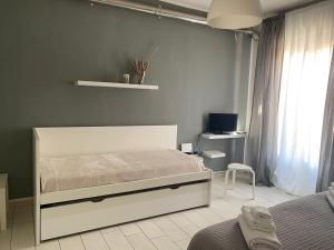 a bedroom with a white bed and a desk at B&b Kamaraton in Marina di Camerota