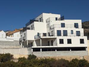 a white building with balconies on the side of it at Casa la Perla Solo adultos in Béznar
