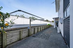 a walkway next to a building next to the ocean at Executive On Parkview - 3BR modern family home in New Plymouth
