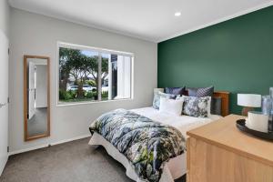 a bedroom with a bed and a window at Executive On Parkview - 3BR modern family home in New Plymouth