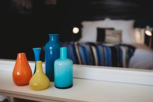 four different colored vases sitting on a table at Te Moana Waterfront - beachside accommodation in New Plymouth